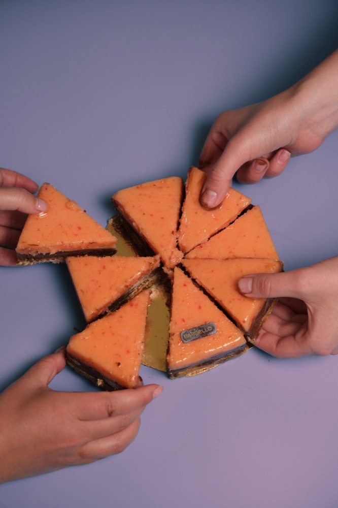 Hands taking slices of a cake, content shoot for Bargello
