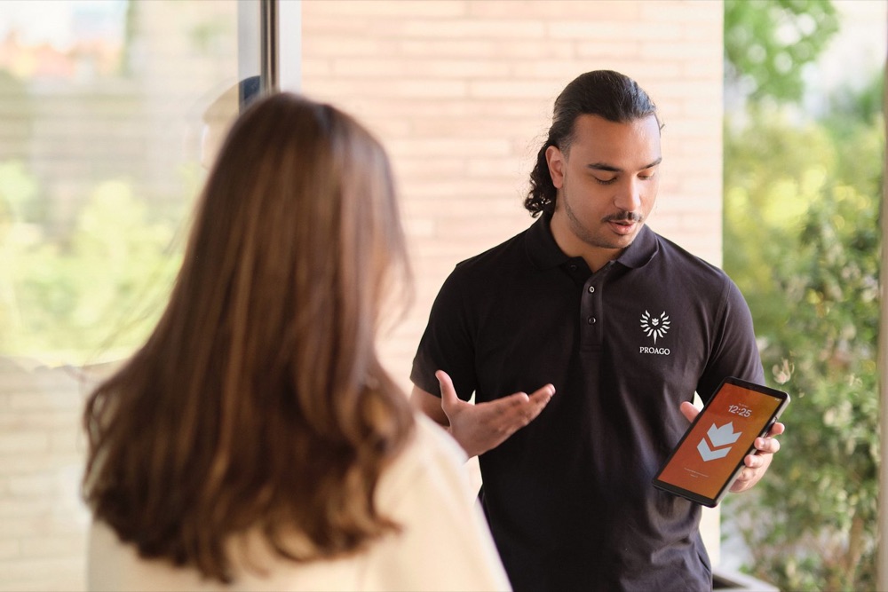 Consultant showing a tablet to a client, content shoot for ProAgo
